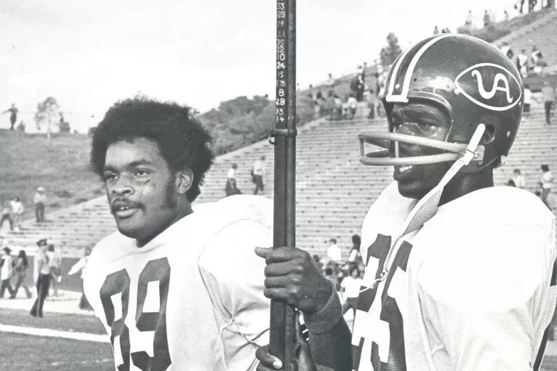 Jackie Wallace (25) and Mark Neal hold the Kit Carson Rifle, awarded in the past  to the winner of the Arizona-New Mexico game (University of Arizona photo)